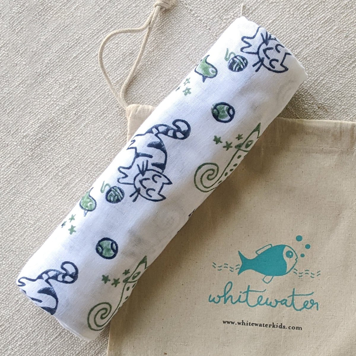 Roll of paper with animal designs on a beige bag featuring 'whitewater' branding.