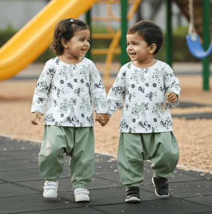 Two children in matching outfits standing on a playground.