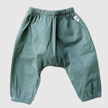 organic cotton Green pants on a textured white surface for kids to wear 