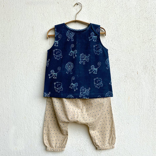 Children's blue sleeveless top with animal patterns and beige harem pants on a white background