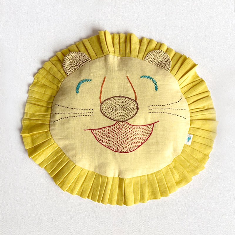 Hand-embroidered organic cotton mustard seeds baby pillow shaped like a lion's face on a white background